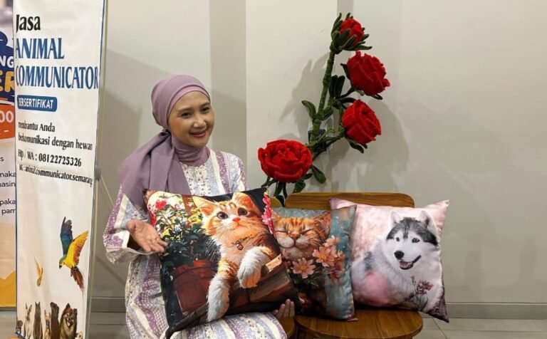 BANTAL KUCING - Dina memegang bantal bergambar kucing buatan tangannya sendiri, Minggu (27/9/2026). Sebagian keuntungan dari jualan bantal kucing itu digunakan untuk memberi makan kucing jalanan. (dul)