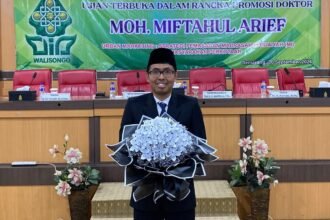 JADI DOKTOR: Moh. Miftahul Arief punya foto dengan buket bunga usai dinyatakan lulus dalam ujian terbuka promosi doktor di UIN Walisomgo Semarang. (ist)