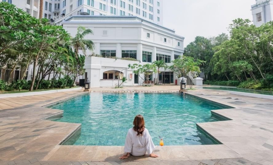 ILUSTRASI: Seorang pengunjung sedang bersantai di pinggir kolam renang Grand Candi Hotel Semarang. (ist)