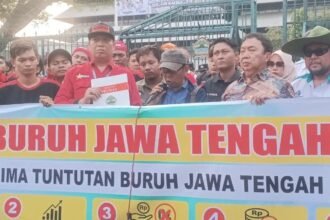 TUNTUT KENAIKAN UPAH - Massa aksi buruh membentangkan spanduk bertuliskan sejumlah tuntutan saat menggelar aksi di depan Kantor Gubernur Jateng (Gubernuran) di Jalan Pahlawan, Kota Semarang, Kamis (1/10/2026).