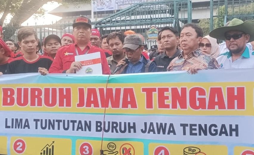 TUNTUT KENAIKAN UPAH - Massa aksi buruh membentangkan spanduk bertuliskan sejumlah tuntutan saat menggelar aksi di depan Kantor Gubernur Jateng (Gubernuran) di Jalan Pahlawan, Kota Semarang, Kamis (1/10/2026).