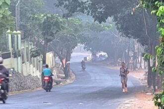 TERDAMPAK ASAP: Warga tetap beraktivitas melintasi Jalan Untung Suropati depan SMAN 7 Semarang meski ada asap kebakaran TPA Jatibarang, Sabtu (3/10/2026). (bae)