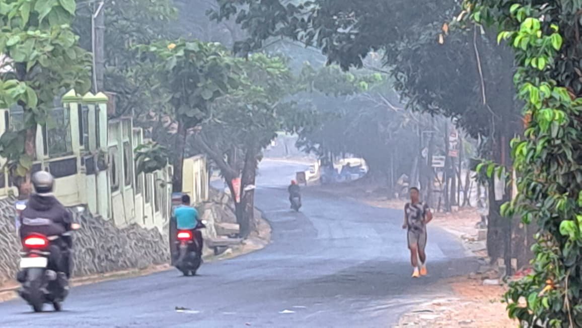 TERDAMPAK ASAP: Warga tetap beraktivitas melintasi Jalan Untung Suropati depan SMAN 7 Semarang meski ada asap kebakaran TPA Jatibarang, Sabtu (3/10/2026). (bae)