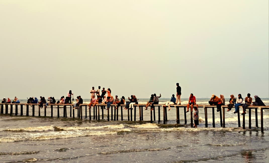 MENIKMATI SENJA: Puluhan orang beraktivitas di dermaga kecil Pantai Tirang Semarang, Sabtu (17/10/2026) sore. (bae)